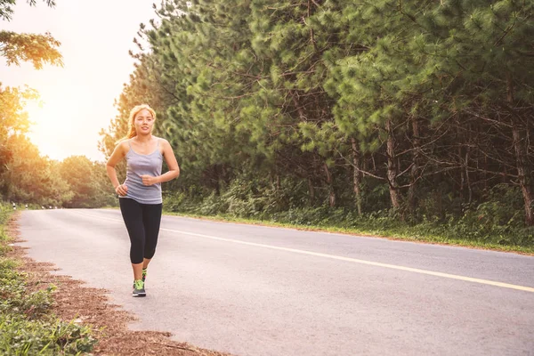 Le donne si esercitano a correre per strada. Parco naturale. La ragazza che fa jogging per la salute. attività fisica, natura, all'aperto, vacanza, sport, relax, Run, travel Thailandia . — Foto Stock