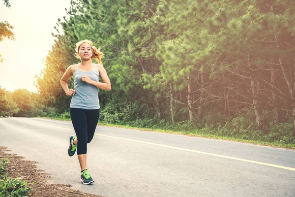 Le donne si esercitano a correre per strada. Parco naturale. La ragazza che fa jogging per la salute. attività fisica, natura, all'aperto, vacanza, sport, relax, Run, travel Thailandia . — Foto Stock