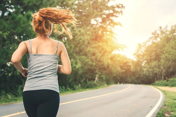 Le donne si esercitano a correre per strada. Parco naturale. esercizio, corsa, buona salute, rilassarsi . — Foto Stock