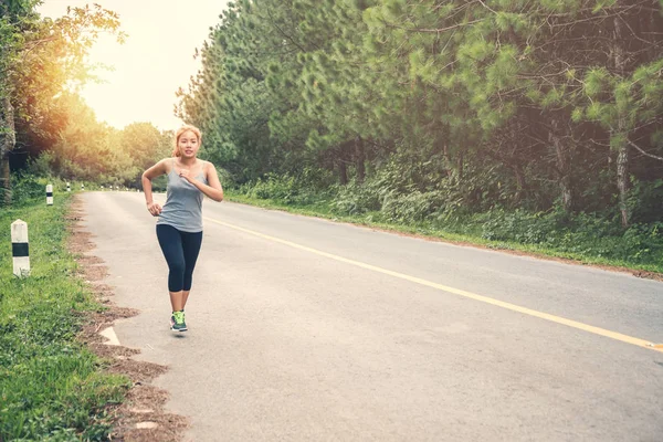 Le donne si esercitano a correre per strada. Parco naturale. esercizio, corsa, buona salute, rilassarsi . — Foto Stock