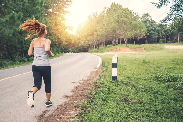 Le donne si esercitano a correre per strada. Parco naturale. esercizio, corsa, buona salute, rilassarsi . — Foto Stock