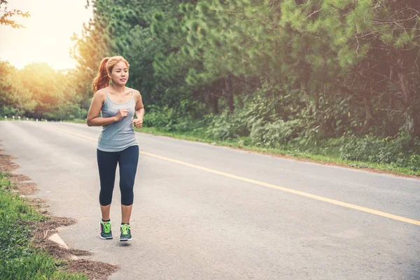 Le donne si esercitano a correre per strada. Parco naturale. La ragazza che fa jogging per la salute. attività fisica, natura, all'aperto, vacanza, sport, relax, Run, travel Thailandia . — Foto Stock
