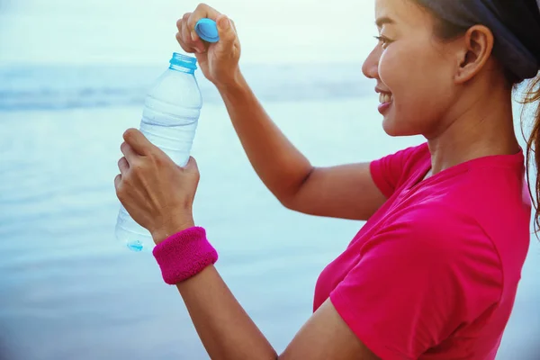 Asian women jogging workout on the beach in the morning. Relax with the sea walk and drinking water from the plastic bottles. summer, beach, nature, outdoor, holiday, sport, exercise, relax, travel Thailand.