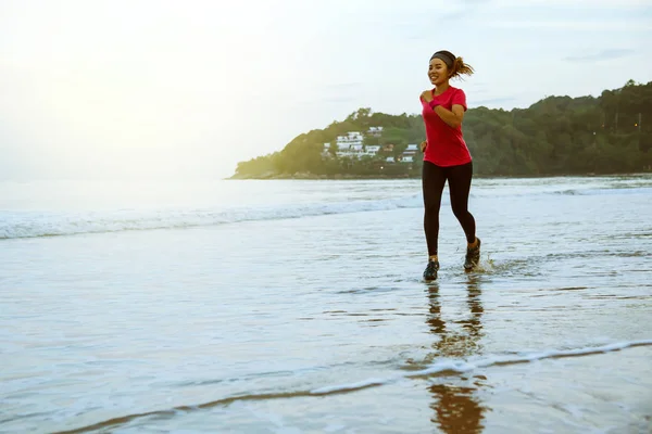 Allenamento di jogging femminile sulla spiaggia al mattino. Rilassati con la passeggiata sul mare. Salta su e divertiti durante l'allenamento. mare, spiaggia, natura, outdoor, vacanza, sport, esercizio, relax, viaggiare Thailandia . — Foto Stock