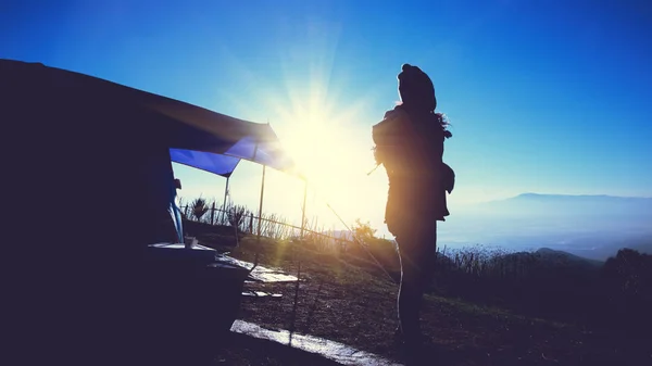 Asian women travel relax in the holiday. camping on the Mountain. Stand watch the sun rise. tent, mountain, camping, countryside, forest, nature, outdoor, holiday, relax, travel, summer, travel Thailand. — Stock Photo, Image