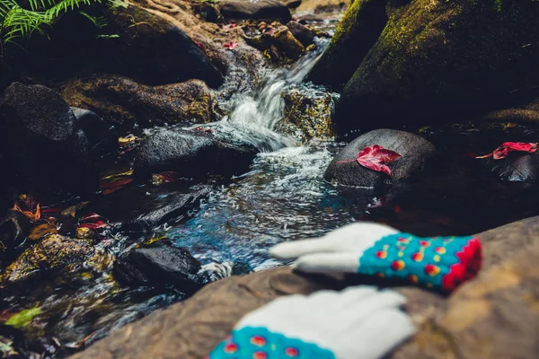 Fondo natural. Hojas de arce en las rocas en la cascada. Guantes de invierno colocados en la piedra . — Foto de Stock