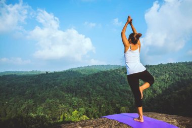 Asyalı kadın tatilde rahatlayın. Seyahat rahatlayın. Yoga varsa oynayın. Moutain kayalıklarında. Tayland dağ ormanlarının doğası