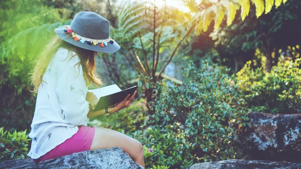 Aziatische vrouw reizen natuur. Reizen ontspannen. Studie een boek lezen. Natuureducatie schrijf een briefje in het openbare park in de zomer. onderwijs, lees een boek, boek, schrijf een notitie, dagboek. — Stockfoto