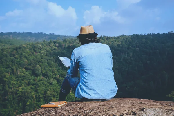 Азиатские мужчины путешествуют отдыхать в отпуске. сидения расслабиться читать книги на скалистых скалах. Летом в Мутене. образование, читать книгу, книгу, писать записку, дневник. Отдыхай. Горный, открытый, отдых, путешествия Таиланд, сельская местность . — стоковое фото