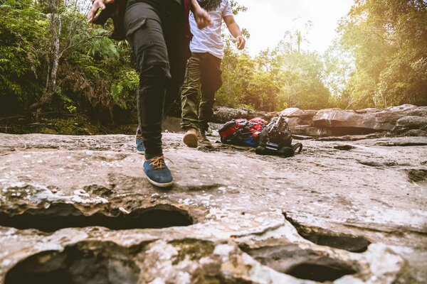 Lover woman and man asians travel relax in the holiday. Walk in the forest. Relax on the rocks. stream dry waterfall caught hole Giants kettles. In thailand