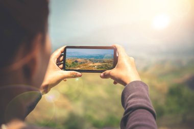 Cep telefonu fotoğrafını kullanan kadın eli. Dağ doğası. Kız doğaya seyahat ediyor. Seyahat rahatlayın. Dağ, Sırt Çantası, açık, tatil, dinlenmek, seyahat Tayland.