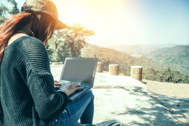 Bir dizüstü bilgisayar kullanarak doğal parkta çalışan bir kadın. Kız doğaya seyahat ediyor. Seyahat rahatlayın. Dağ, açık, tatil, seyahat Tayland, kırsal. Dizüstü bilgisayar, bilgisayar, eğitim.