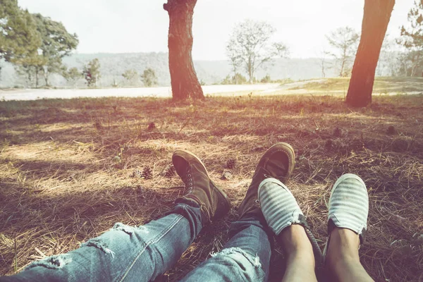 Las piernas de los hombres y mujeres que yacen en un prado en unas vacaciones. Pareja asiática naturaleza de viaje. Relájate. Montaña, al aire libre, vacaciones, relajarse, viajar Tailandia . — Foto de Stock