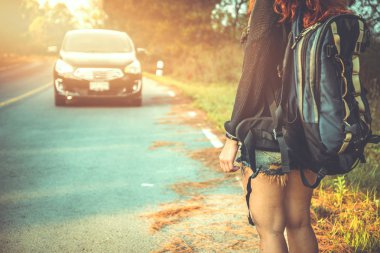 Sırt çantasıyla seyahat eden kadınlar araba sallıyor. tatilde. Yol, Trafik güzergahı, Kırsal yol, kırsal, Orman, rota, yaz, doğa, açık, tatil, dinlenmek, seyahat Tayland.