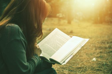 Parkta kitap okuyan bir kadın. Holiday. eğitim, kitap okumak, kitap okumak, not yazmak, günlük