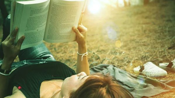 Donna rilassante lettura nel parco. vacanza Sonno riposo in lettura. Giovani donne si rilassano, dormono, leggono libri durante le vacanze. natura, all'aperto, vacanza, educazione, leggere un libro, libro, Scrivere una nota, diario . — Foto Stock