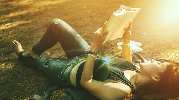 Woman relaxing reading in park. holiday Sleep rest in reading. Young women relax, sleep, read books during the holidays. nature, outdoor, holiday, education, read a book, book, Write a note, diary.