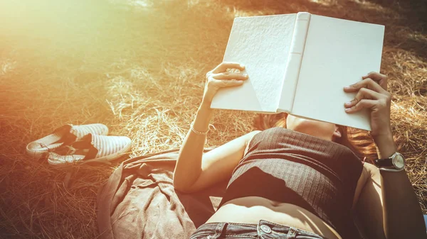 Vrouw ontspannen lezen in Park. vakantie slaap rust in het lezen. Jonge vrouwen ontspannen, slapen, boeken lezen tijdens de feestdagen. natuur, buiten, vakantie, onderwijs, lees een boek, boek, schrijf een notitie, dagboek. — Stockfoto