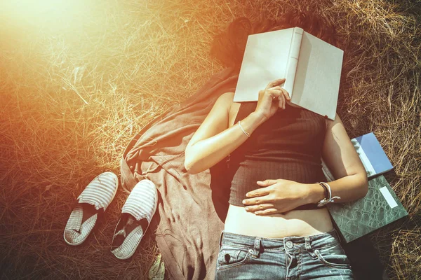 Женщина отдыхает, читая в парке. Отдых Сон отдых в чтении. Молодые женщины отдыхают, спят, читают книги во время праздников. природа, отдых на свежем воздухе, образование, чтение книги, книги, записка, дневник . — стоковое фото