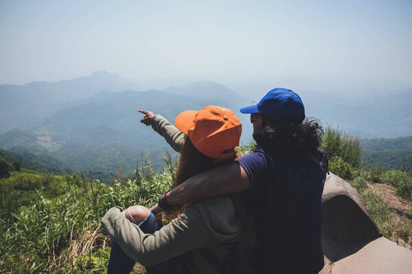 Lover couple women and men Asians travel relax in the holiday. Stand up landscape on the Mountain. Mountain Park happily.hiking in mountains. In Thailand