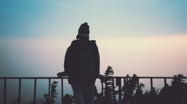 Asyalı kadınlar tatilde rahatlarlar. Dağda gün doğumu için ayağa kalkın. Kışın. Tayland'da