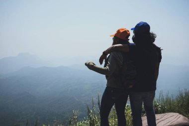 Sevgili çift kadın ve erkek Asyalılar tatilde dinlenmek seyahat. Oturup Dağ'daki manzarayı izleyin. Mountain Park mutlu. dağlarda yürüyüş. Tayland'da