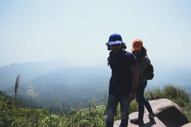 Sevgili çift kadın ve erkek Asyalılar tatilde dinlenmek seyahat. Oturup Dağ'daki manzarayı izleyin. Mountain Park mutlu. dağlarda yürüyüş. Tayland'da