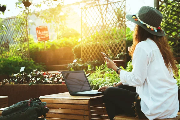 Asian woman relax. work with a laptop. And play the phone.At the coffee shop.