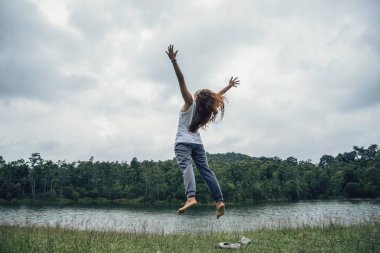 Asyalı kadınlar tatilde rahatlarlar. Yeşil bir çayır üzerine atlamak