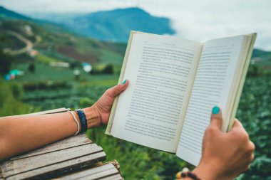 Kitap okuyan kadınları el ele. Sabah atmosferi Dağlar sisli. phetchabun phutubberg tayland