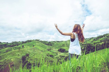 Asyalı kadınlar tatilde rahatlarlar. yeşil bir çayırda. dağlarda yürüyüş