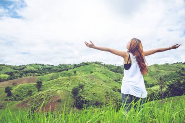 Asyalı kadınlar tatilde rahatlarlar. yeşil bir çayırda. dağlarda yürüyüş