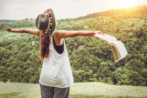 As mulheres asiáticas relaxam nas férias. Stand ler livros sobre pastagens no parque . — Fotografia de Stock