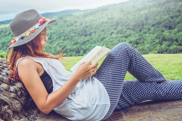 아시아 여성은 휴일에 휴식을 취합니다. 공원 벤치에서 책 읽기. — 스톡 사진