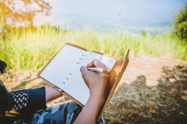 Le donne asiatiche viaggiano rilassandosi durante la vacanza. campeggio sulla Montagna. Siediti, scrivi un biglietto sulla sedia. Tailandia — Foto Stock