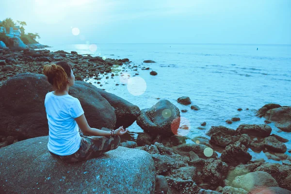 Азиатка путешествует расслабиться в праздник. Играй, если йога. На скалах у моря . — стоковое фото