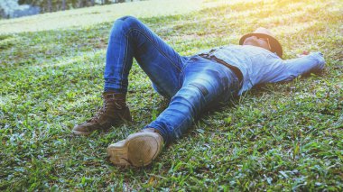 Asya adam seyahat tatilde rahatlayın. Dağ üzerinde çim üzerinde dinlenmek uyku. Tayland 'da
