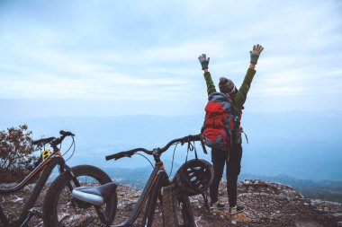  Asyalı kadın Seyahat fotoğraf Doğa. Vahşi doğada bir bisiklet Wilderness binmek seyahat rahatlayın. Kayalık bir uçurumun üzerinde duruyor. Tayland 