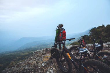  Asyalı kadın Seyahat fotoğraf Doğa. Vahşi doğada bir bisiklet Wilderness binmek seyahat rahatlayın. Kayalık bir uçurumun üzerinde duruyor. Tayland 