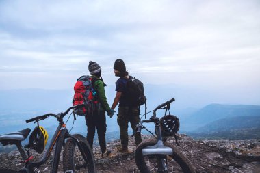  Asyalı çiftler kadın ve erkek Seyahat Doğa. Vahşi doğada bir bisiklet Wilderness binmek seyahat rahatlayın. Kayalık bir uçurumun üzerinde duruyor. Tayland 