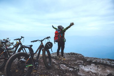  Asyalı kadın Seyahat fotoğraf Doğa. Vahşi doğada bir bisiklet Wilderness binmek seyahat rahatlayın. Kayalık bir uçurumun üzerinde duruyor. Tayland 