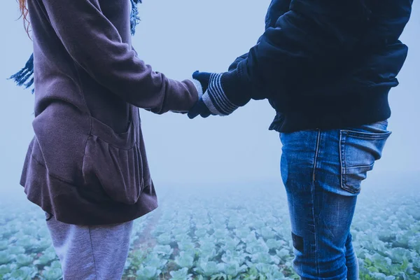 Amantes mulheres e homens asiáticos viajar relaxar no feriado. Feliz por viajar no feriado. Os amantes andam de mãos dadas no campo de arroz. Durante o inverno nebuloso — Fotografia de Stock