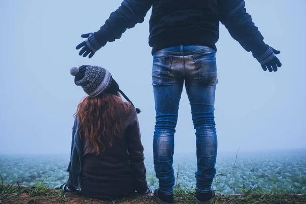 Amante de las mujeres y los hombres Los asiáticos viajan relajarse en las vacaciones. Feliz de viajar en las vacaciones. Los amantes caminan de la mano en el campo de arroz. Durante el invierno brumoso — Foto de Stock