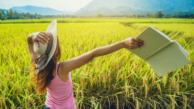 Asyalı kadınlar tatilde dinlenir. Tatilde kitap okurum. Doğal bahçe pirinç tarlası hakkında bir çalışma yaz..