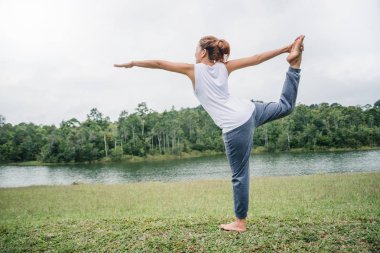 Asyalı kadınlar tatilde dinlenir. Yoga yap. Yeşil bir pastada