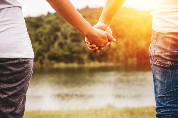 恋人の男性と女性アジア人は休日にリラックスします。草原を歩く手を握って — ストック写真