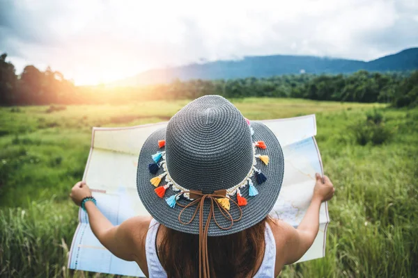 Uma mulher viaja. Mulheres asiáticas ver mapa viajar natureza no prado — Fotografia de Stock