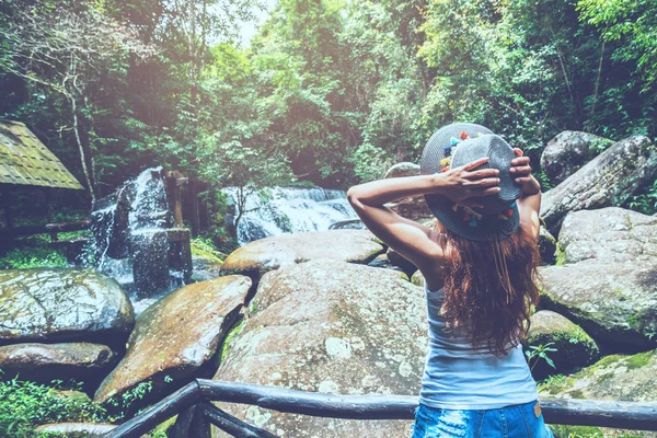 Las mujeres asiáticas viajan relajarse en las vacaciones. Fotografía con cascada Atracciones Históricas —  Fotos de Stock