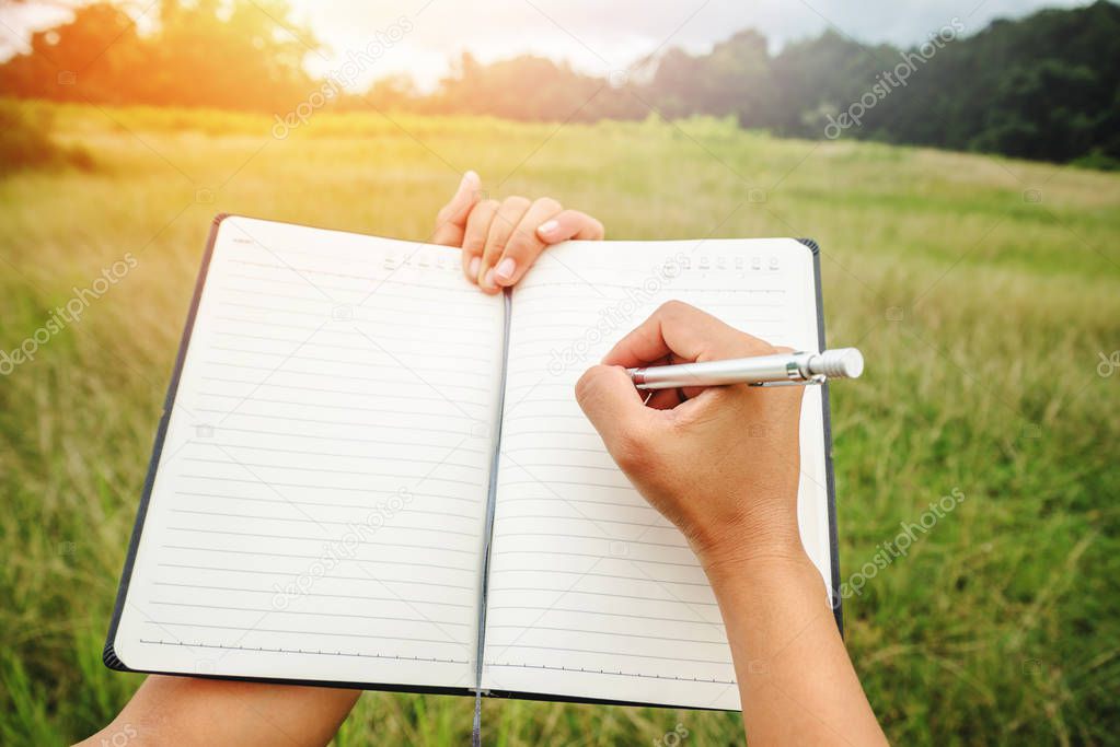 Handwriting on notebook relax in the holiday. on a green pasture