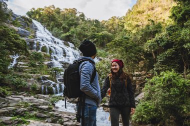 Seyahat etmek çiftlerin şelalelerini ziyaret etmek için rahatlatır. Kışın. Tayland 'daki Mae ya Chiangmai şelalesinde. Seyahat doğası. yaz